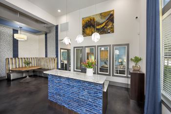 A reception area with a blue tile counter and a striped couch.